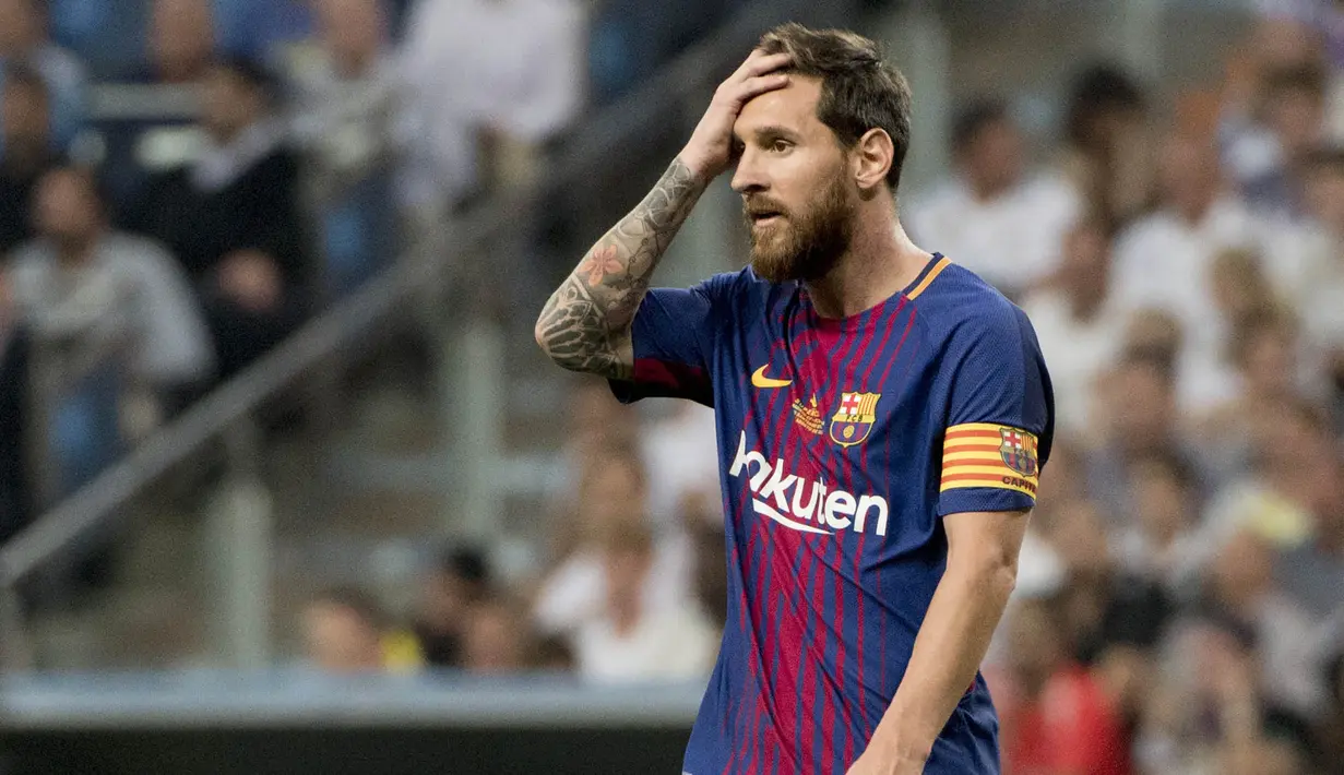 Striker Barcelona, Lionel Messi, memegang kepalanya usai takluk dari Real Madrid pada laga Piala Super Spanyol 2017 di Stadion Santiago Bernabeu, Rabu (16/8/2017). Real Madrid menang 2-0 atas Barcelona. (AFP/Curto De La Torre)
