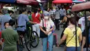 Seorang perempuan yang mengenakan masker berjalan di sepanjang kios darurat, setelah pelonggaran lockdown, di pusat kota Manila, Filipina, Rabu (2/9/2020). Pemerintah melonggarkan lockdown meskipun negara tersebut memiliki infeksi virus corona terbanyak di Asia Tenggara. (AP Photo/Aaron Favila)