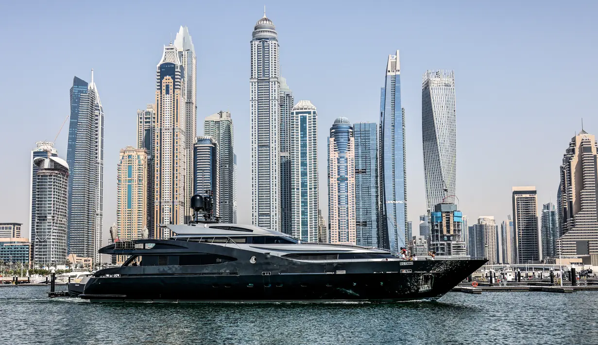 Sebuah kapal pesiar mewah digambarkan di Dubai Marina Beach, emirat Teluk pada 10 Juni 2021. Di tengah aturan pandemi di mana warga harus menjaga jarak dan menghindari keramaian, orang-orang kaya di Dubai memiliki cara untuk bisa pergi berekreasi, yaitu mode wisata kapal pesiar. (Karim SAHIB/AFP)