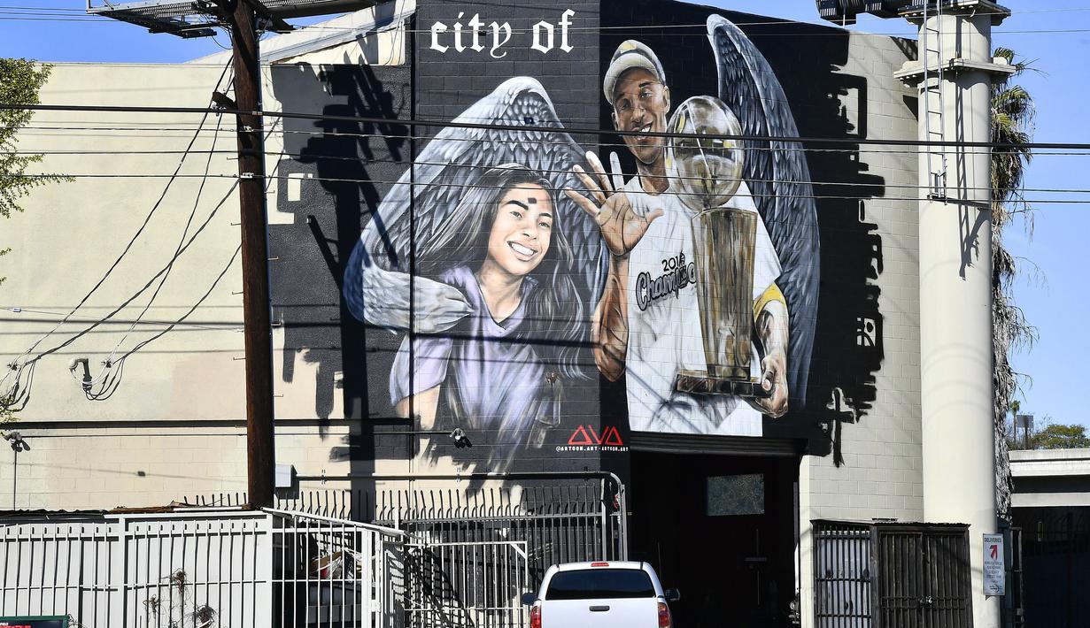 Lukisan mural bintang LA Lakers, Kobe Bryant bersama putrinya, Gianna karya seniman Artoon Art terpampang di jalanan Los Angeles, California, Selasa (26/1/2021). Lukisan dibuat untuk mengenang 1 tahun tragedi kecelakaan helikopter yang menewaskan keduanya. (Getty Images via AFP/Frazer Harrison)