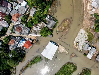 Foto udara menunjukkan pemandangan rumah-rumah penduduk dan jalan yang terendam air akibat luapan sungai sebagai dampak longsornya tumpukan sampah yang menyumbat aliran sungai di Depok pada 7 Mei 2024. (BAY ISMOYO/AFP)