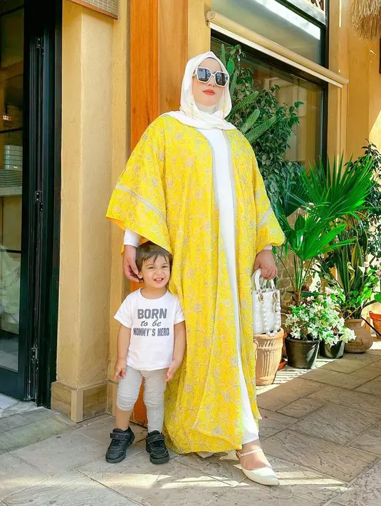 Tampil modis, Tasyi memadukan dress putih dengan outer panjang warna kuning dan tas Dior-nya. [Foto: IG/tasyiiathasyia].