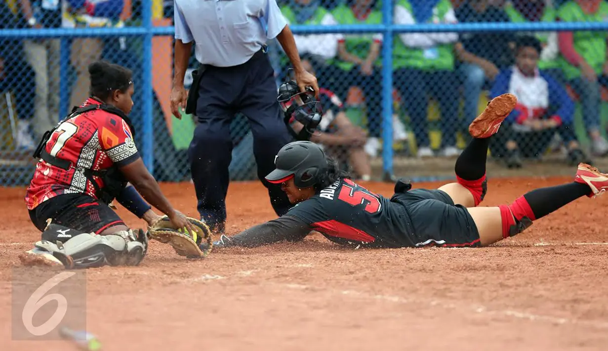 Pesoffball putri DKI Jakarta, Sarah Adipayanti (kanan) melompat masuk home base saat laga melawan Papua di penyisihan PON XIX di Lapangan Softball UPI, Bandung, Sabtu (24/6). DKI Jakarta menang 16-0 atas Papua. (Liputan6.com/Helmi Fithriansyah)
