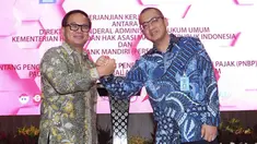 Dirut Bank Mandiri Kartika Wirjoatmodjo dan Dirjen AHU Kemenkumham Cahyo Rahadian Muzhar bersalaman usai penandatanganan perjanjian kerja sama di Jakarta, Kamis (1/8/2019). Bank Mandiri menyediakan fasilitas layanan pembayaran PNBP secara online/realtime. (Liputan6.com/Angga Yuniar)