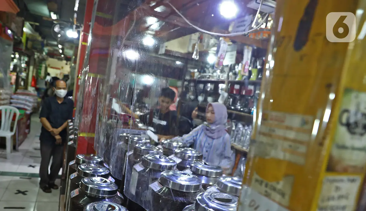 Pembeli sedang berbelanja di Pasar Santa, Jakarta, Selasa (23/6/2020). Plastik pembatas antara pedagang dan pembeli dipasang di kios pasar santa diterapkan dari protokol kesehatan pencegahan COVID-19. (Liputan6.com/Herman Zakharia)