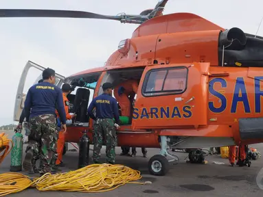 Penyelam TNI-AL memasukan perlengkapan untuk mengangkat ekor AirAsia ke dalam helikopter di Lanud Iskandar, Pangkalan Bun, Kalteng, Sabtu (10/1/2015).  (Liputan6.com/Andrian M Tunay)