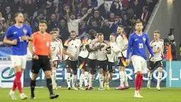 Toni Kroos bersama para pemain Jerman merayakan gol ke gawang Prancis pada laga persahabatan di Stadion Groupama, Minggu (24/3/2024). Pemain Real Madrid ini kembali hadir dengan sebuah assist dalam kemenangan atas Prancis. (AP Photo/Laurent Cipriani)