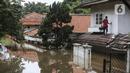 Warga berjalan di atap rumah saat banjir merendam kawasan Kemang, Jakarta, Sabtu (20/2/2021). Curah hujan yang tinggi menyebabkan kawasan tersebut terendam banjir setinggi orang dewasa. (Liputan6.com/Johan Tallo)