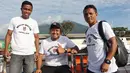 Dua pemain Malut United, Ridwan Tawainella (kiri) dan Hendra Adi Bayauw (kanan), berfoto bersama asisten pelatih Achmad Resal (tengah) di atas geladak kapal. (Bola.com/Okie Prabhowo)