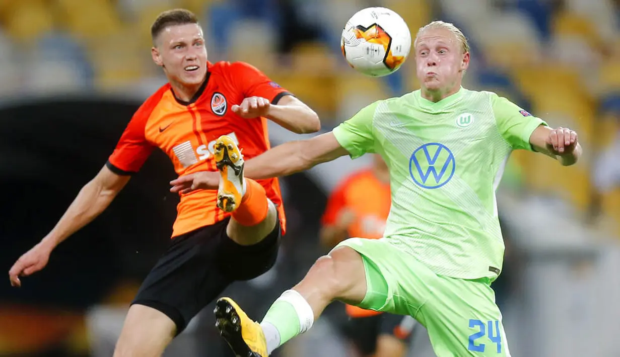 Pemain FC Shakhtar Donetsk, Mykola Matviyenko, berebut bola dengan pemain VfL Wolfsburg, Xaver Schlager, pada laga Liga Europa di Stadion NSK Olimpiyskiy, Kiev, Rabu (5/8/2020). Shakhtar Donetsk menang 3-0 atas Wolfsburg. (AP/Efrem Lukatsky)