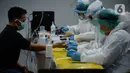 Petugas medis mengambil sempel darah calon penumpang pesawat di Terminal 3 Bandara Soekarno Hatta, Tangerang, Banten, Rabu (29/7/2020). Tarif rapid test di Bandara Soekarno-Hatta tarif sesuai Surat Edaran Ditjen Pelayanan Kesehatan Kemenkes tentang batasan tarif Rp 150.000. (merdeka.com/Dwi Narwoko)