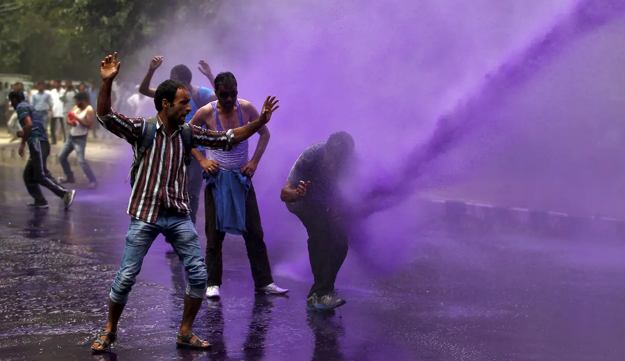 Sejumlah PNS terkena semprotan meriam air yang ditembakan polisi saat membubarkan unjuk rasa di Srinagar, India, Senin (10/8/2015). Dalam aksinya, para PNS tersebut menuntut pembayaran gaji mereka yang tertunggak. (REUTERS/Danish Ismail)