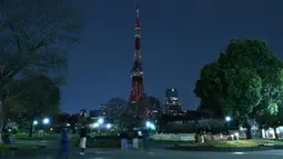 Foto kombinasi menunjukkan landmark Menara Tokyo yang menyala (atas) dan dengan lampu dimatikan (bawah) untuk menandai kampanye Earth Hour di Tokyo (27/3/2021). (AFP/Kazuhiro Nogi)