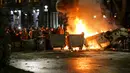 Para pengunjuk rasa berkumpul pada barikade dengan mobil polisi yang terbakar tidak jauh dari Gedung Parlemen Georgia di Tbilisi, Georgia, Kamis (9/3/2023). Tahun lalu, Georgia adalah salah satu negara yang ditolak Uni Eropa untuk mendapatkan status negara calon anggota, selain Moldova dan Ukraina, dengan alasan ketiga negara itu lamban mereformasi politik dan sistem peradilan mereka. (AP Photo/Zurab Tsertsvadze)