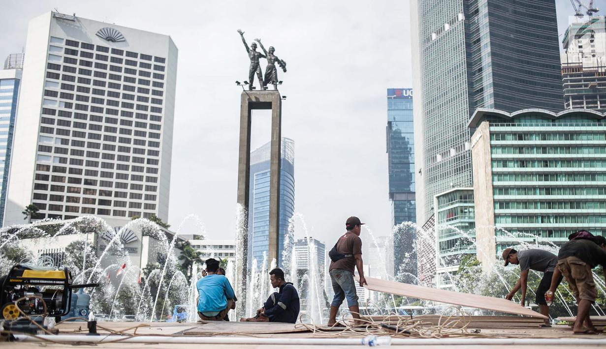 Sejumlah pekerja menyelesaikan pembuatan panggung HUT ke-492 DKI di area Bundaran HI, Jakarta, Kamis (20/6/2019). Panggung megah tersebut nantinya akan digunakan sebagai area pesta rakyat. (Liputan6.com/Faizal Fanani)