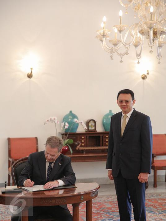 Presiden Finlandia Sauli Vainamo Niinisto mengisi buku tamu disaksikan Gubernur DKI Basuki Tjahaja Purnama di Balai Kota DKI Jakarta, Rabu (4/11). Keduanya melakukan diskusi tertutup dalam rangka membahas peluang kerjasama. (Liputan6.com/Faizal Fanani)