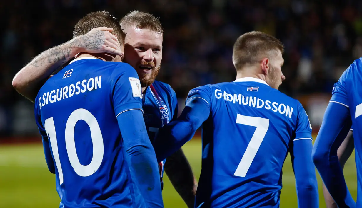 Kapten timnas Islandia, Aron Gunnarsson dan timnya  merayakan kemenangan atas Kosovo pada laga Grup I Kualifikasi Piala Dunia 2018 di Laugardalsvollur, Senin (9/10). Menang 2-0, Islandia pertama kalinya lolos ke gelaran Piala Dunia (AP/Brynjar Gunnarsson)