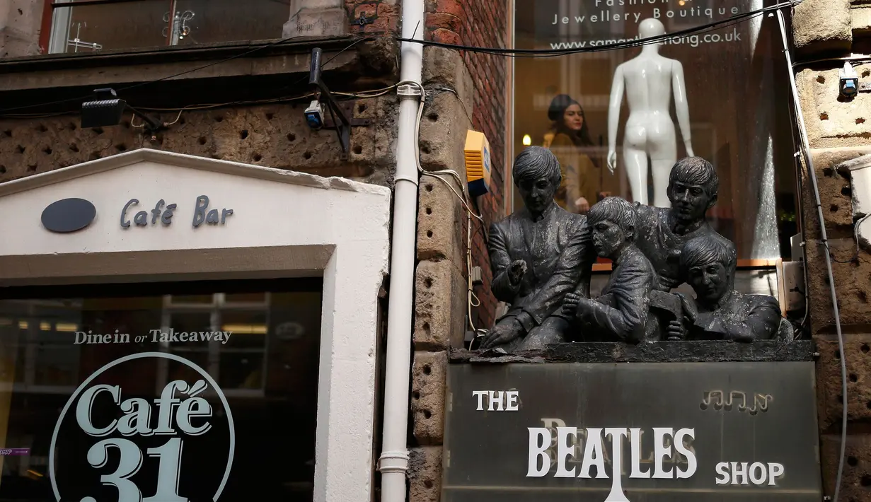 Seorang wanita tampak dari jendela sebuah toko bernama Beatles Shop di Liverpool, Inggris, (2/3). Warga Liverpool Peringati 50 tahun terakhir kali The Beatles melakukan konser di kota asal mereka ini. (REUTERS/Phil Noble)