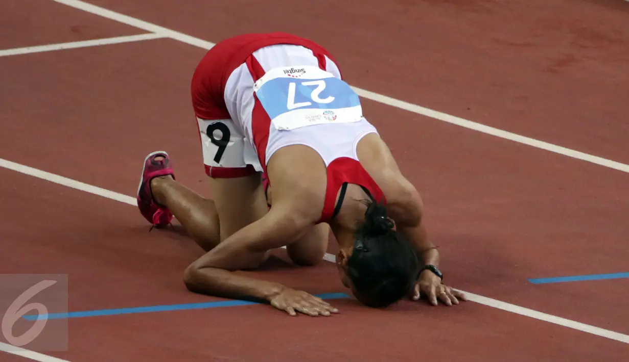 Atlet Indonesia, Rini Budiarti bersujud usai finish pertama lari halang rintang 3.000 meter SEA Games ke-28 di National Stadium, Singapura, Jumat (12/6/2015). Rini mencatat waktu 10 menit 20,40 detik. (Liputan6.com/Helmi Fithriansyah)