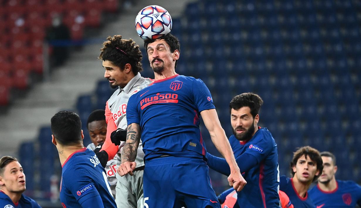 Bek Atletico Madrid, Stefan Savic, menyundul bola saat menghadapi RB Salzburg pada laga lanjutan Grup A Liga Champions di Red Bull Arena, Kamis (10/12/2020) dini hari WIB. Atletico Madrid menang 2-0 atas RB Salzburg. (AFP/Joe Klamar)