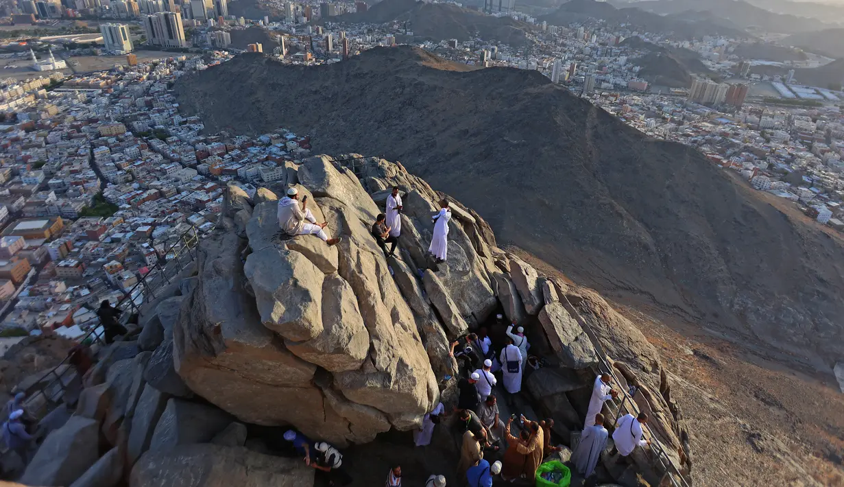 Peziarah muslim berfoto di Jabal al-Noor atau Gunung Cahaya yang menghadap ke Kota Suci Mekkah, Arab Saudi, 5 Juli 2022. Satu juta orang, termasuk 850 ribu dari luar negeri, diizinkan untuk berpartisipasi dalam haji tahun ini setelah dua tahun terakhir jumlahnya dikurangi secara drastis karena pandemi virus corona COVID-19. (Christina ASSI/AFP)