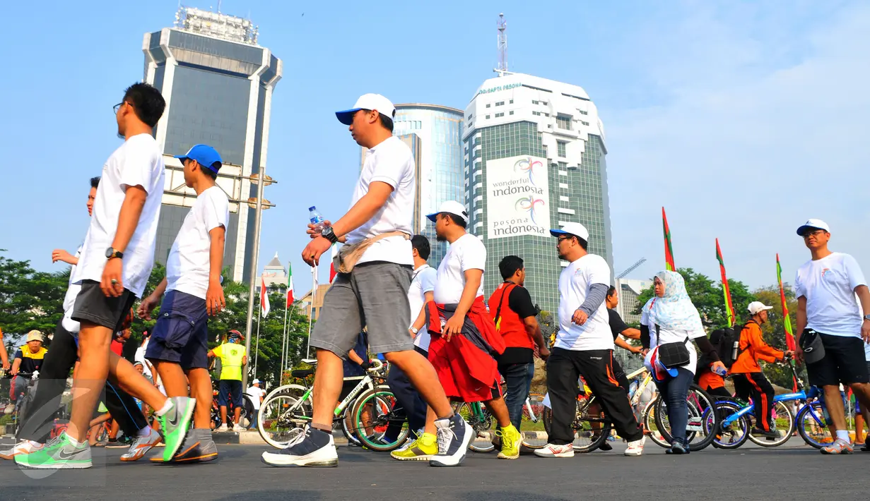 Para peserta Fun Walk memperingati ke-70 Hari Bakti Postel menuju bundaran HI dengan berjalan santai, Jakarta, Minggu (8/11/2015). Acara ini digelar Kemkominfo untuk mengenang jasa para pahlawan telekomunikasi Indonesia. (Liputan6.com/Faisal R Syam) 
