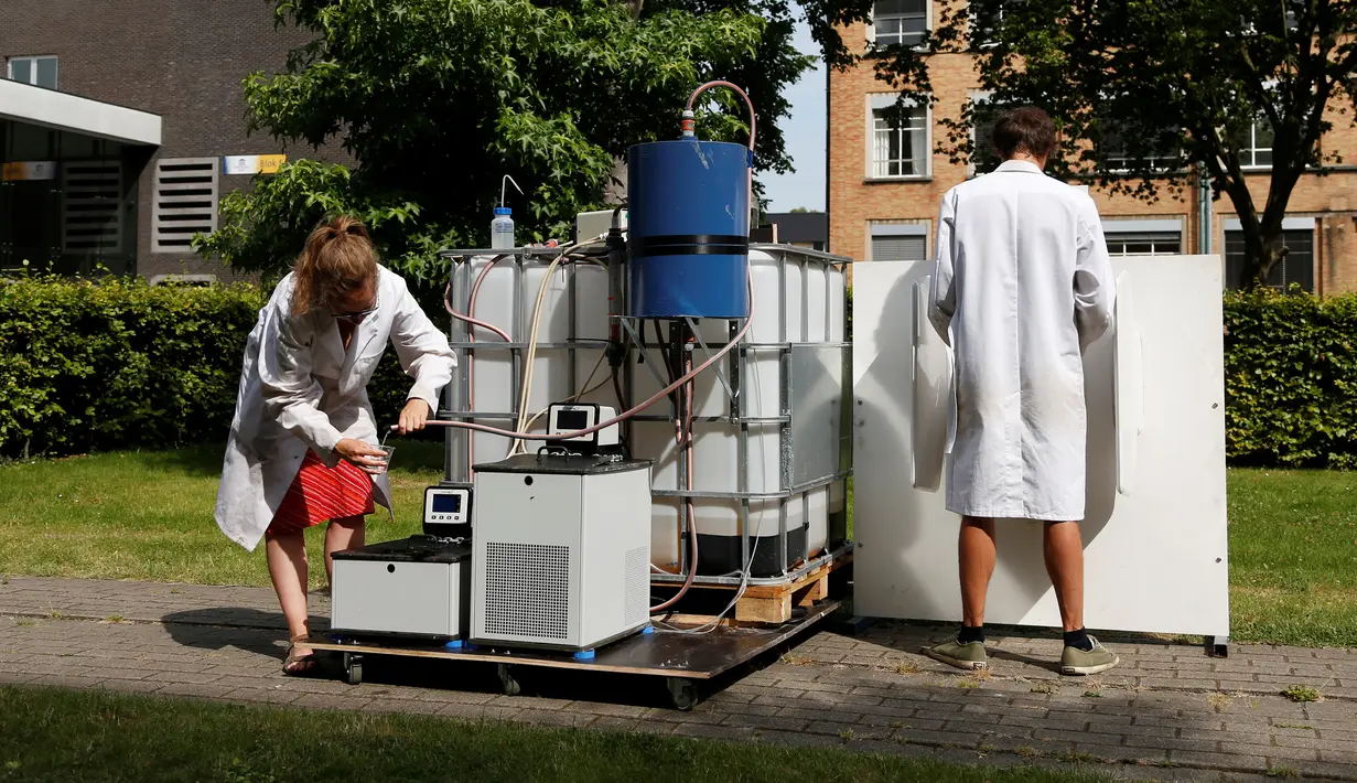 Ilmuwan Belgia, Marjolein Vanoppen dan Sebastiaan Derese menunjukkan penggunaan mesin yang bisa mengubah air seni menjadi air diminum dan menjadi pupuk dengan bantuan energi matahari di University of Ghent, Belgia, Selasa (26/7). (REUTERS/Francois Lenoir)