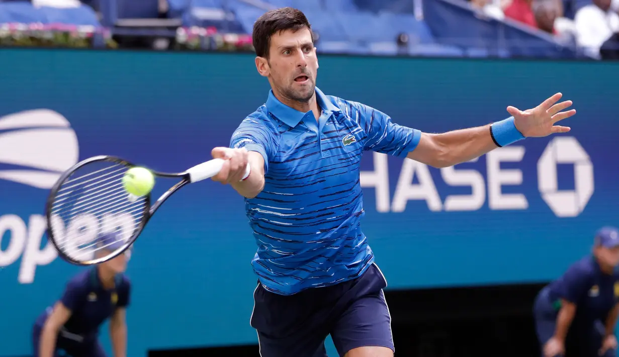 Petenis Serbia, Novak Djokovic mengembalikan bola ke arah lawannya Roberto Carballes Baena dari Spanyol pada  babak pertama AS Terbuka 2019 di Billie Jean King National Tennis Center, New York, Senin (26/8/2019). Unggulan pertama itu memetik kemenangan 6-4, 6-1, 6-4. (AP/Frank Franklin II)