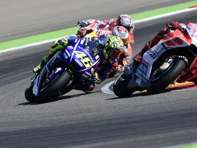 Pembalap Movistar Yamaha, Valentino Rossi dan pembalap Ducati Team, Jorge Lorenzo memacu motor mereka pada balapan MotoGP Aragon di Spanyol, Minggu (24/9). Rossi comeback setelah satu seri absen akibat cedera kaki kanan. (JAVIER SORIANO/AFP)