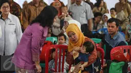 Ibu Negara, Iriana Widodo berbincang dengan warga saat menyambangi Puskesmas Ciracas, Jakarta, Senin (18/7). Iriana Widodo datang untuk memantau pemberian vaksin ulang terhadap anak-anak yang dulunya diberikan vaksin palsu. (Liputan6.com/Faizal Fanani)