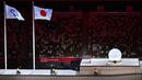 Tiga pembawa obor mengangkut api Paralimpiade sebelum menyalakan kuali (kanan) selama upacara pembukaan Paralimpiade Tokyo 2020 di Stadion Olimpiade di Tokyo pada 24 Agustus 2021. (AFP/Charly Triballeau)