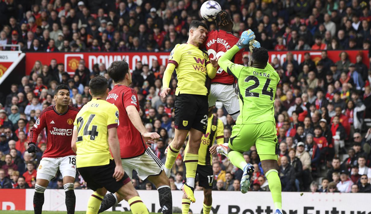 Kiper Manchester United, Andre Onana berusaha menghalau bola dari ancaman pemain Burnley, Zeki Amdouni (tengah) yang berujung pelanggaran yang diganjar tendangan penalti pada laga pekan ke-35 Premier League 2023/2024 di Old Trafford Stadium, Manchester, Sabtu (27/4/2024). (AP Photo/Rui Vieira)