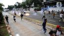 Pengunjuk rasa tolak UU Cipta Kerja bentrok dengan polisi di sekitar Patung Kuda, Jakarta Pusat, Selasa (13/10/2020). Gas air mata ditembakkan ke arah pendemo yang melakukan perlawanan dengan melempar batu dan pecahan kaca. (Liputan6.com/Faizal Fanani)