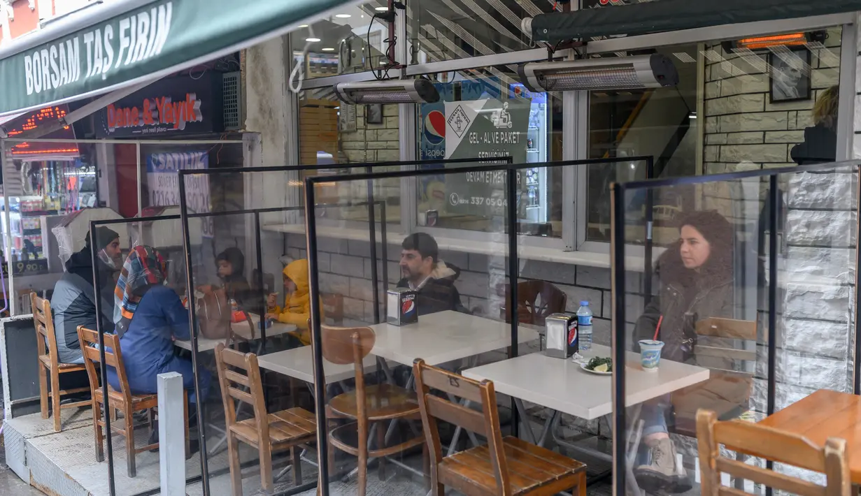 Orang-orang makan siang di sebuah restoran di Kadikoy, Istanbul, setelah negera tersebut melonggarkan pembatasan, Selasa (2/3/2021). Pemerintah Turki menutup semua restoran untuk makan di tempat pada November dan memberlakukan penguncian wilayah pada akhir pekan secara nasional. (BULENT KILIC/AFP)