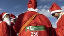 Orang-orang yang mengenakan kostum Sinterklas bersiap untuk ambil bagian dalam Athens Santa Run, di Athena, Yunani, Minggu (12/12/2021). Ratusan orang berpartisipasi mengikuti lomba lari untuk acara amal di area sekitar kompleks Stadion Olimpiade Athena. (AP Photo/Yorgos Karahalis)