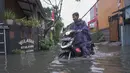 Warga melintasi genangan air di kawasan RT 10 RW 08, Kelurahan Gedong, Kecamatan Pasar Rebo, Jakarta Timur, Senin (4/8/2025). (merdeka.com/Arie Basuki)