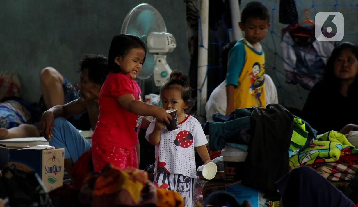 Anak-anak bermain di lokasi pengungsian Gor Total Persada, Periuk, Tangerang, Banten, Kamis (6/2/2020).Seribuan warga perumahan itu mengungsi karena tanggul Kali Ledug jebol. hingga  kawasan perumahan itu terendam air dengan ketinggian 3,5 meter. (merdeka.com/Muhammad Fayyadh)