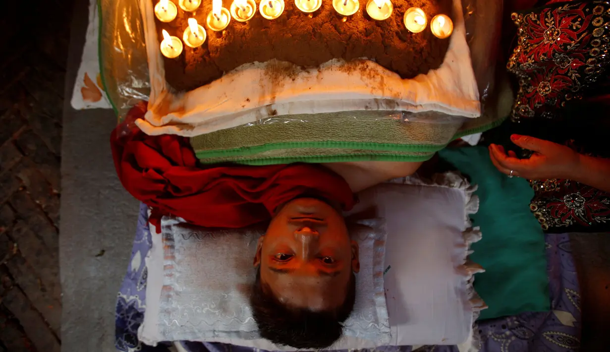 Tubuh seorang pemuja yang dipenuhi lampu minyak, dan sambil berdoa dalam upacara Dashian yang di gelar di Bhaktapur, Nepal (11/10).  Upacara Dashian merupakan sebuah acara besar di Nepal yang digelar 5 tahun sekali. (REUTERS/Navesh Chitrakar)