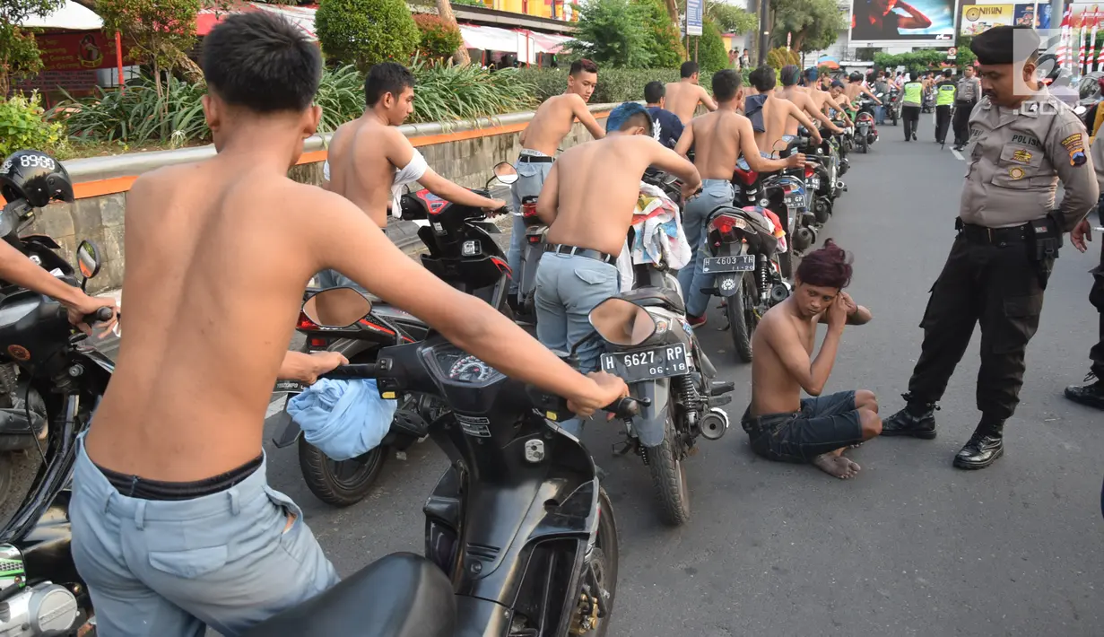 Aparat kepolisian menggelandang ratusan pelajar SMA yang konvoi usai pengumuman kelulusan UN di Bundaran Simpang Lima, Semarang, Jawa Tengah, Kamis (3/5). (Liputan6.com/Gholib)