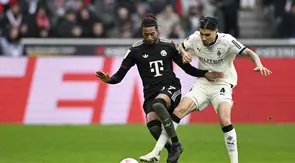 Bek Borussia Monchengladbach, Kevin Diks mencoba merebut bola dari penguasaan winger Bayern Munchen, Michael Olise dalam laga Bundesliga 2025/2026 di Borussia Park, Sabtu (25/10/2025). (AFP/Ina Fassbender)
