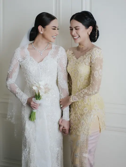 Ini adalah potret momen pernikahan Amanda, didampingi oleh Maudy. Amanda tampil cantik memesona dalam balutan kebaya brokat panjang, lengkap dengan penutup kepalanya yang transparan, sedangkan Maudy mendampingi sang adik dalam balutan kebaya brokat yang cantik bernuansa kuning, terlihat pas untuk kulit cerahnya. Foto: Instagram.