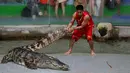 Petugas kebun binatang menarik seekor buaya di Sriracha Tiger Zoo, Provinsi Chonburi , Thailand , 7 Juni 2016. Buaya yang dikenal dengan binatang buas ini dengan mudahnya bermain dengan petugas kebun binatang tersebut. (REUTERS / Chaiwat Subprasom)