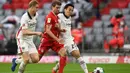 Penyerang Bayern Munchen, Thomas Mueller, berebut bola dengan bek Eintracht Frankfurt, Martin Hinteregger, pada laga lanjutan Liga Jerman di Allianz Arena, Sabtu (24/10/2020) malam WIB. Bayern Munchen menang 5-0 atas Eintracht Frankfurt. (AFP/Christof Stache/various sources)