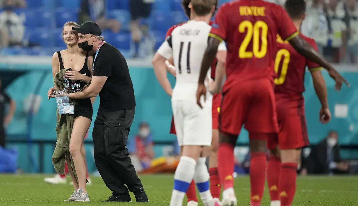 Tak berapa lama kemudian, salah satu petugas keamanan berhasil menangkap wanita tersebut dan membawanya ke luar lapangan. (Foto: AP/Pool/Dmitri Lovetsky)