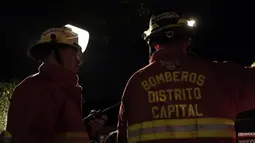 Petugas pemadam kebakaran berada di lokasi terjadinya kebakaran di sebuah panti jompo swasta di Caracas, Venezuela, Minggu (23/8/2015) waktu setempat. Delapan orang penghuni panti tewas dalam peristiwa tersebut. (AFP PHOTO/JUAN BARRETO)