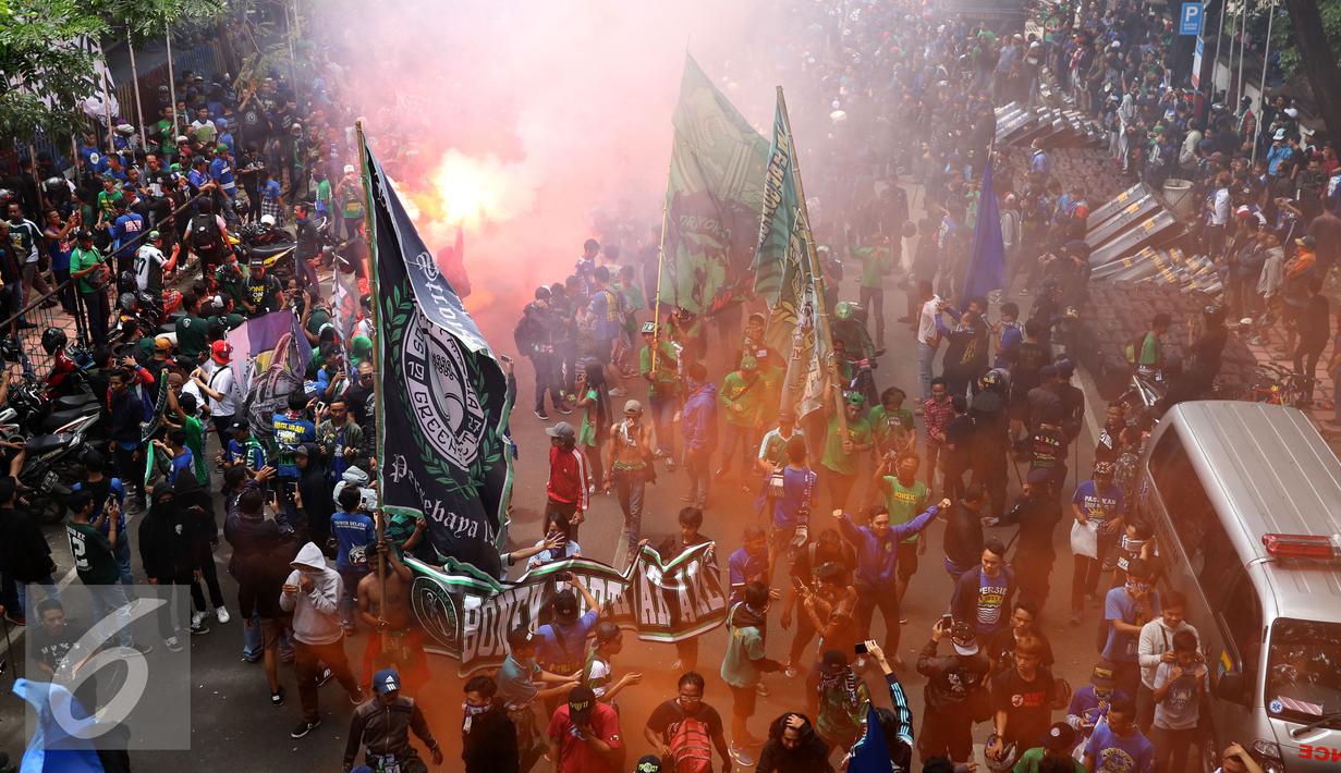 Pendukung Persebaya menyalakan suar di ruas jalan Padjajaran saat merayakan kembalinya klub mereka ke kompetisi PSSI, Bandung, Minggu (8/1). Berdasar putusan Kongres PSSI 2017, Persebaya 1927 kembali ke divisi utama. (Liputan6.com/Helmi Fithriansyah)