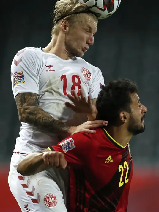 Pemain Denmark, Daniel Wass berebut bola udara dengan pemain Belgia, Nacer Chadli pada pertandingan UEFA Nations League di stadion King Power di Leuven, Belgia, Rabu (18/11/2020). Belgia meraih satu tiket ke semifinal UEFA Nations League usai menang 4-2 atas Denmark. (AP Photo/Francisco Seco)