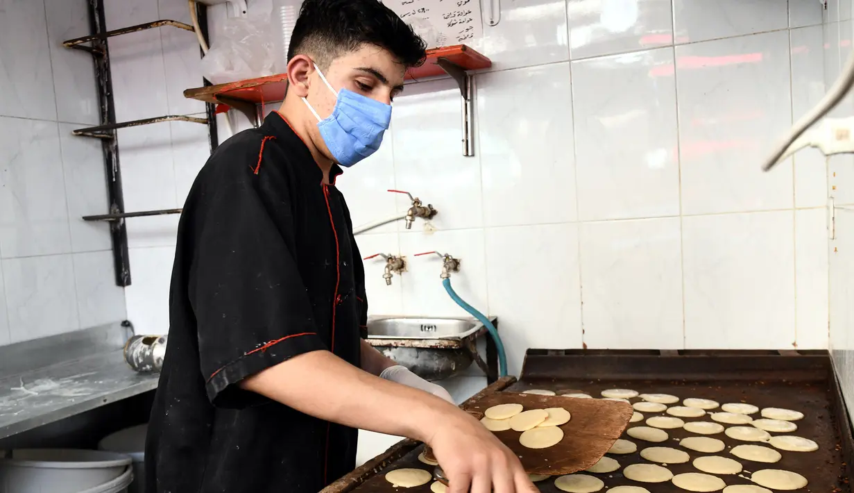 Seorang pedagang Suriah membuat "Qatayef", penganan manis tradisional yang biasa disajikan saat bulan suci Ramadan di Damaskus, Suriah, (18/5/2020). (Xinhua/Ammar Safarjalani)