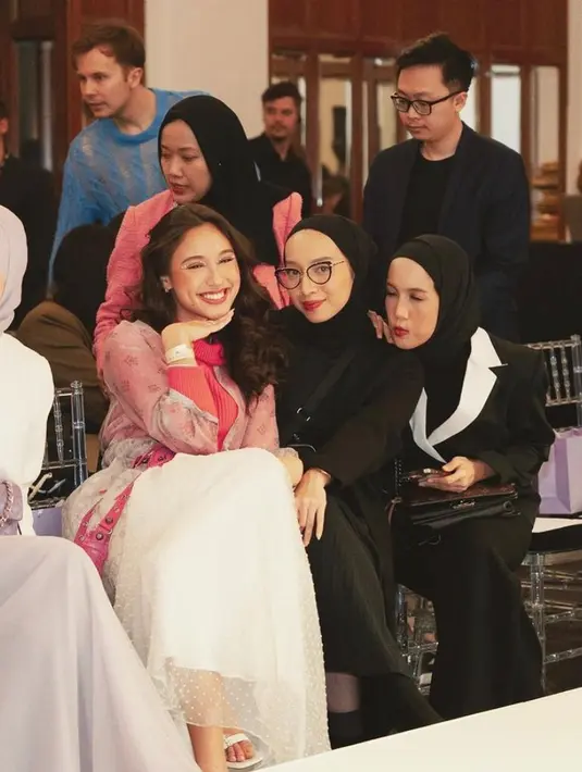 Penampilannya ini dilengkapi dengan heels putih ditambah sling bag warna pink.