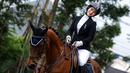 Selebritas Indonesia, Melody Laksani berpose di atas kuda saat bersiap berkompetisi dalam cabang olahraga berkuda nomor show jumping Turnamen Olahraga Selebriti Indonesia (TOSI) Season 3 yang berlangsung di Arthayasa Stable, Depok, Jawa Barat, Jumat (01/11/2024). (Bola.com/Bagaskara Lazuardi)